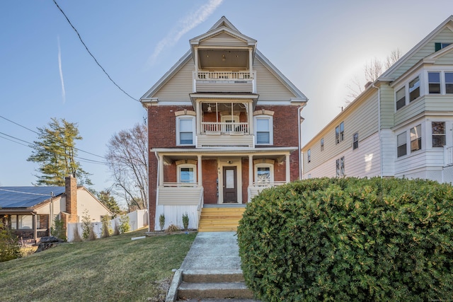 45 Willis St, Bristol, CT 06010 - victorian-style house with brick siding, fence, a porch, a front yard, and a balcony