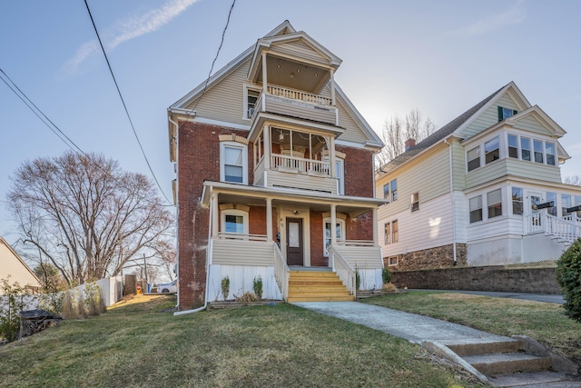 45 Willis St, Bristol, CT 06010 - view of front of home with a front lawn, a porch, a balcony, fence, and brick siding