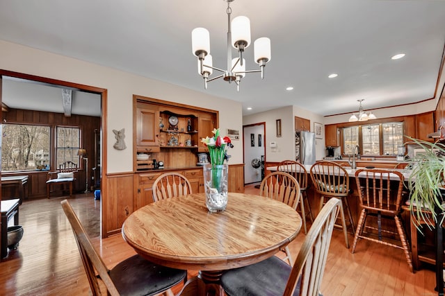 dining space with a healthy amount of sunlight, a notable chandelier, and light wood finished floors