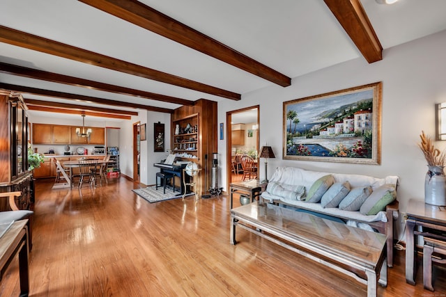living area with beamed ceiling and wood finished floors
