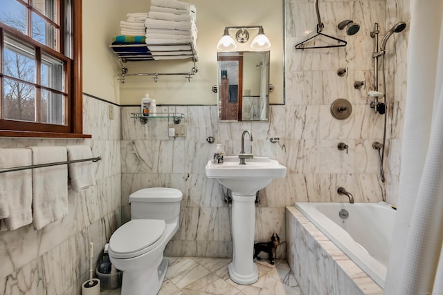 full bath with a sink, marble finish floor, toilet, and tiled shower / bath