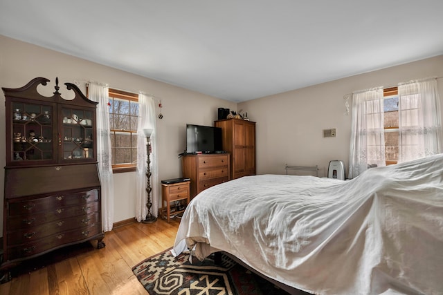 bedroom with light wood-style flooring and baseboards