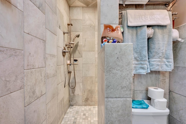 full bathroom featuring toilet and a tile shower