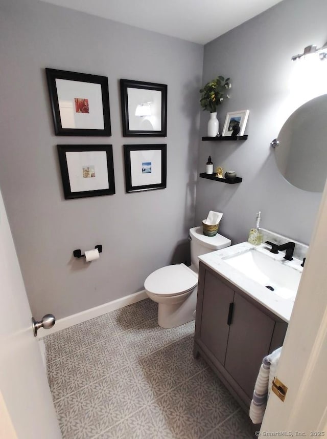 half bathroom with tile patterned floors, vanity, and toilet