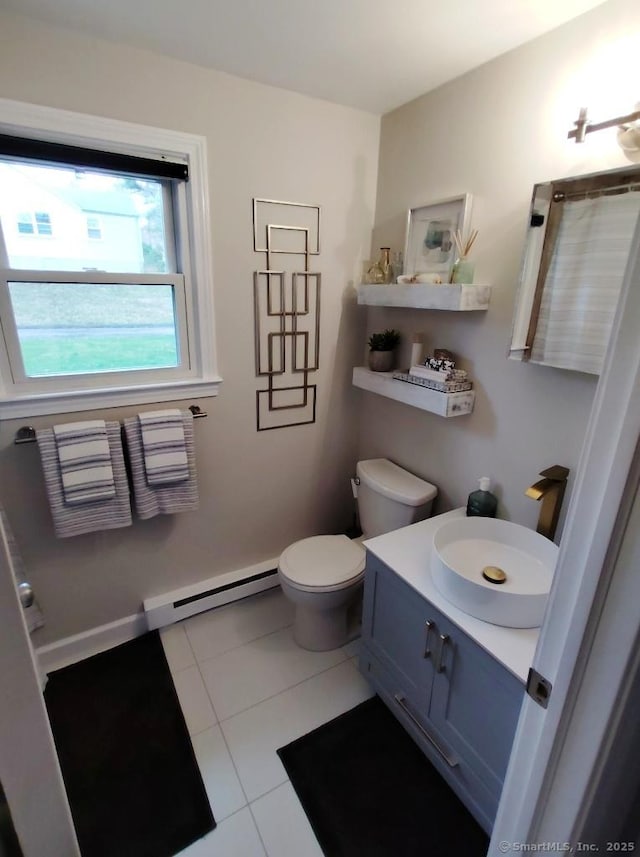 bathroom featuring tile patterned flooring, toilet, a baseboard heating unit, and vanity