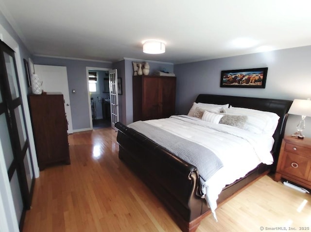 bedroom featuring crown molding, baseboards, and light wood-type flooring