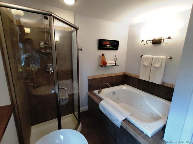 full bath with a shower stall, tile patterned floors, and a jetted tub
