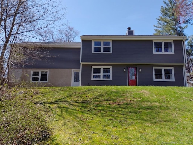 view of front of house with a front lawn and a chimney