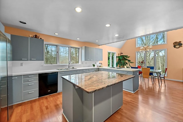 kitchen featuring a peninsula, gray cabinetry, a wealth of natural light, and dishwasher