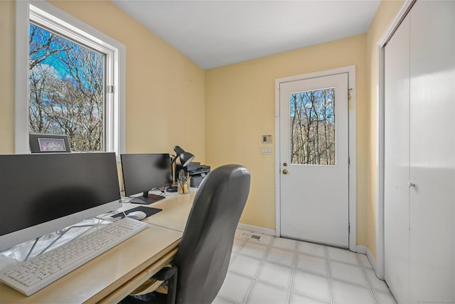 office with baseboards, visible vents, and light floors