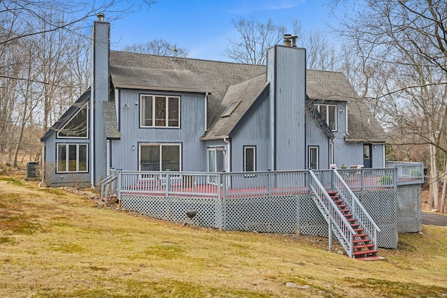 back of house featuring a shingled roof, a chimney, and a deck