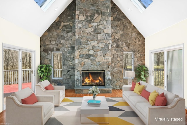 living room with a skylight, high vaulted ceiling, a fireplace, and wood finished floors