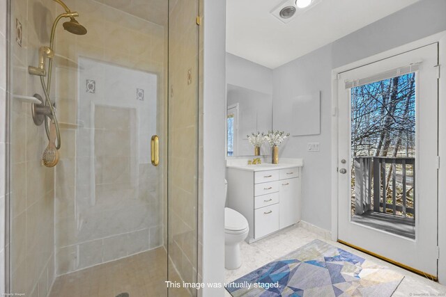 full bath with vanity, toilet, baseboards, and a stall shower