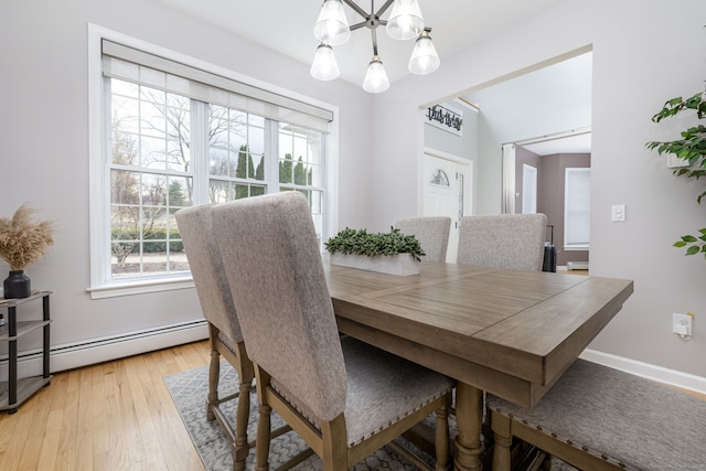 dining space with baseboards, a chandelier, light wood-type flooring, and a baseboard radiator