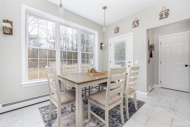 dining area featuring marble finish floor, baseboards, baseboard heating, and plenty of natural light