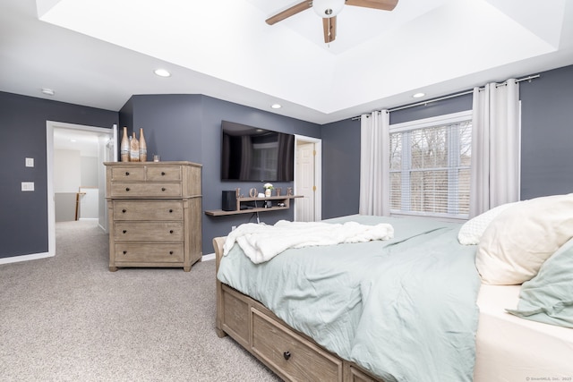 bedroom featuring a ceiling fan, light carpet, a raised ceiling, baseboards, and recessed lighting