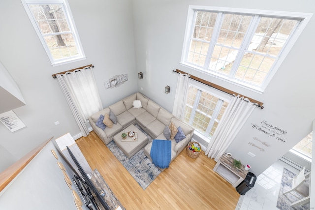 living area featuring wood finished floors and a towering ceiling