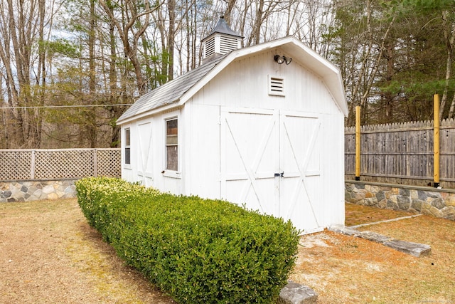 view of shed featuring fence