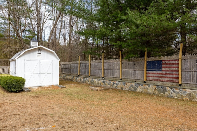 view of yard with an outbuilding, a storage unit, and a fenced backyard