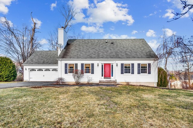 view of front of home with aphalt driveway, a front lawn, a garage, and a chimney