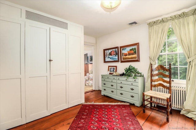 living area featuring radiator heating unit and hardwood / wood-style flooring