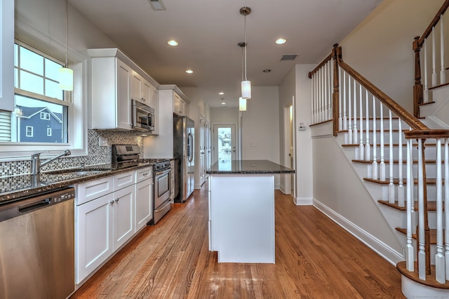 36 Deerfield Ave, Milford, CT 06460 - kitchen featuring appliances with stainless steel finishes, a sink, light wood-type flooring, a kitchen island, and visible vents