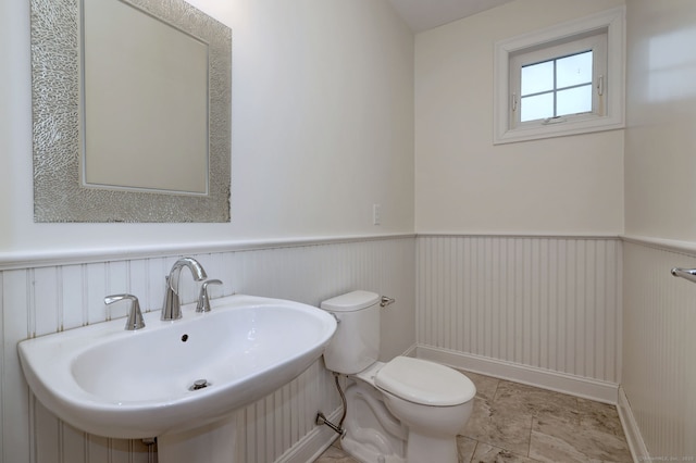 36 Deerfield Ave, Milford, CT 06460 - half bathroom with toilet, a sink, and a wainscoted wall