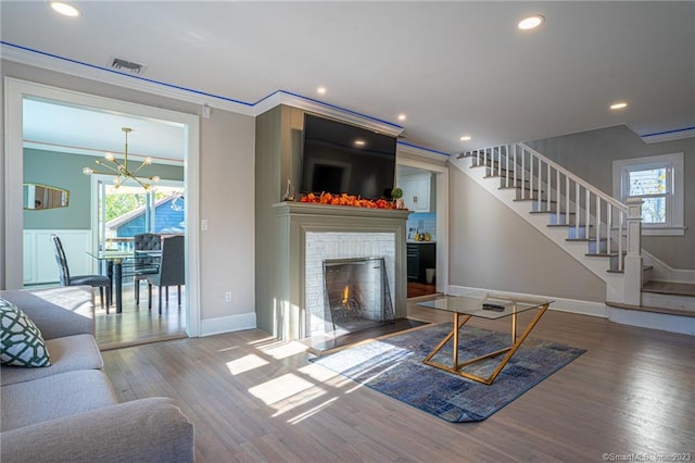 18 Fenway St, Stamford, CT 06902 - living area with visible vents, stairs, ornamental molding, an inviting chandelier, and wood finished floors
