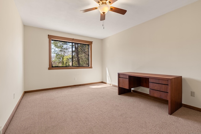 spare room featuring baseboards, light carpet, and a ceiling fan