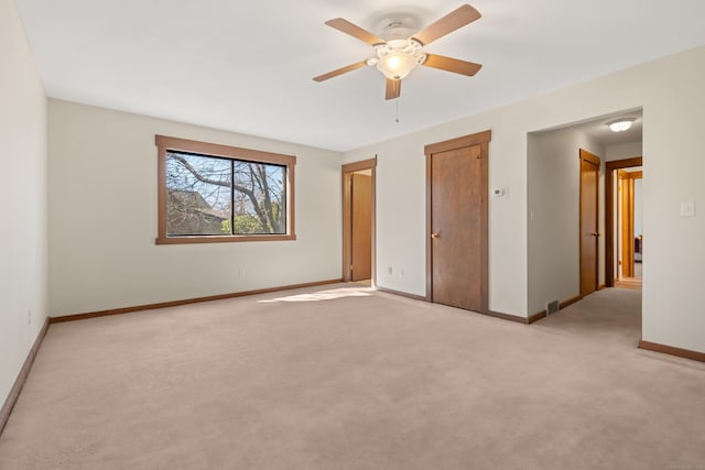 unfurnished bedroom with ceiling fan, visible vents, baseboards, and light carpet
