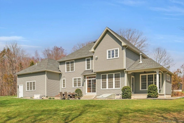back of house featuring a lawn, central AC, a shingled roof, and entry steps