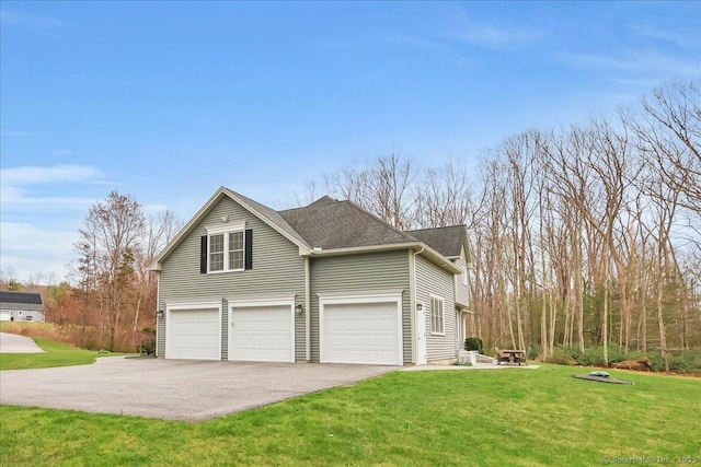 view of home's exterior with a lawn, an attached garage, aphalt driveway, and a shingled roof