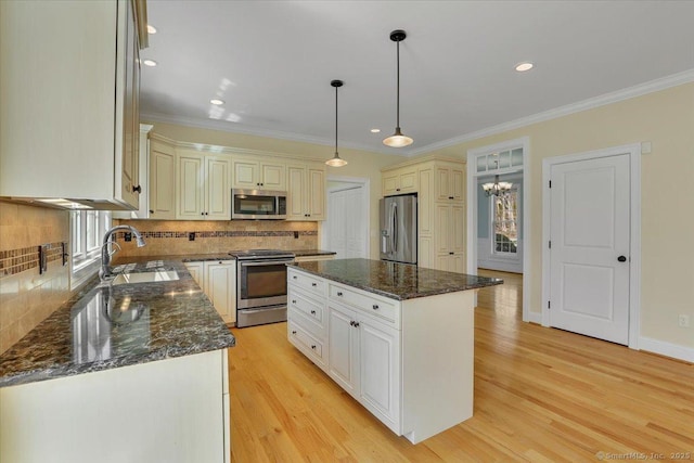 kitchen featuring tasteful backsplash, appliances with stainless steel finishes, ornamental molding, and a sink