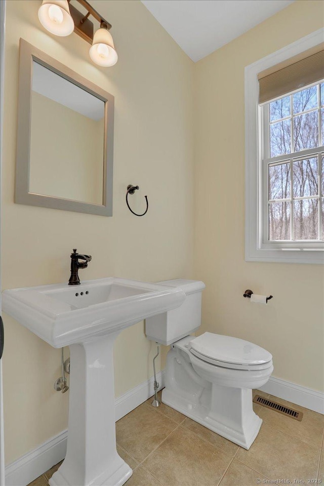 bathroom with baseboards, visible vents, tile patterned flooring, and toilet