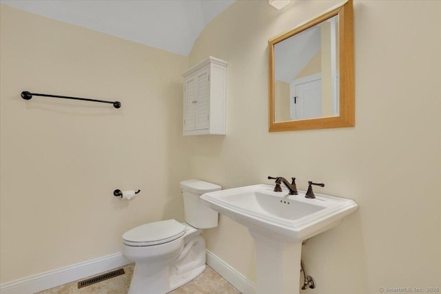 bathroom featuring baseboards, visible vents, tile patterned floors, and toilet