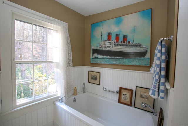 11 Hodge Rd, Roxbury, CT 06783 - bathroom with wainscoting, a bath, and plenty of natural light