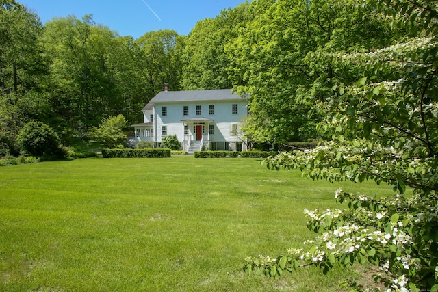 11 Hodge Rd, Roxbury, CT 06783 - view of front facade with a front lawn, a forest view, and a chimney