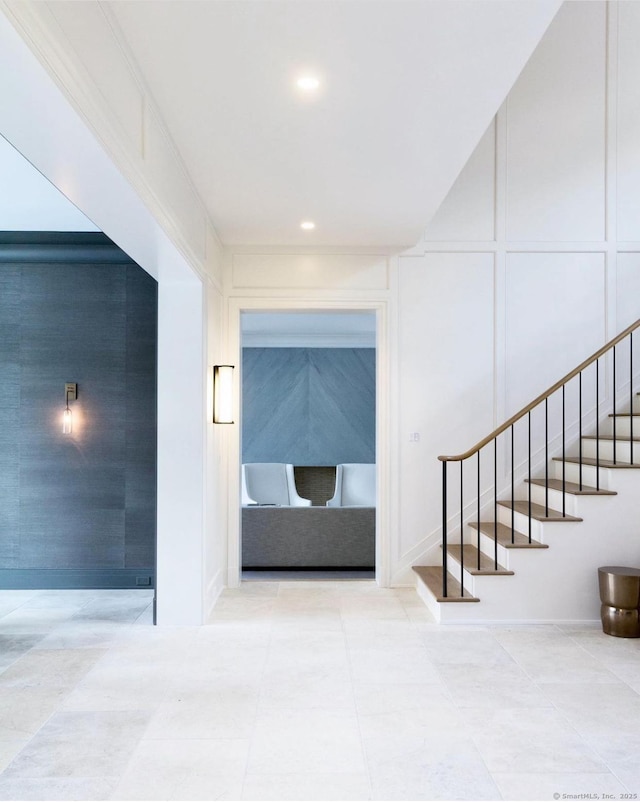 hallway featuring a decorative wall, stairs, tile patterned floors, and recessed lighting