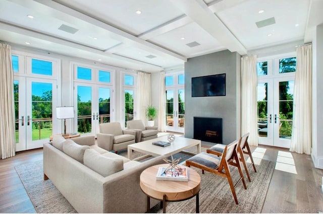 living area with french doors, wood finished floors, beamed ceiling, a fireplace, and coffered ceiling