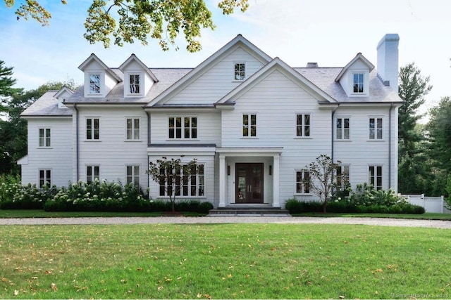 view of front of home with a front yard and a chimney