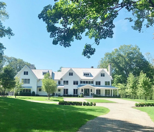 view of front of house featuring a chimney and a front lawn