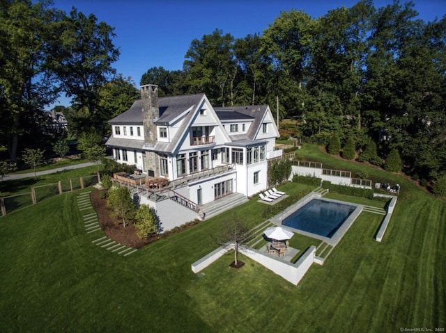 rear view of house featuring a patio, a chimney, and an outdoor pool