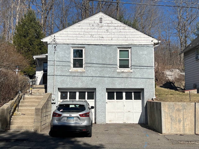 exterior space with driveway, stucco siding, and an attached garage