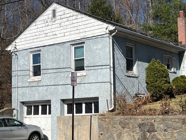 view of home's exterior with stucco siding and a garage
