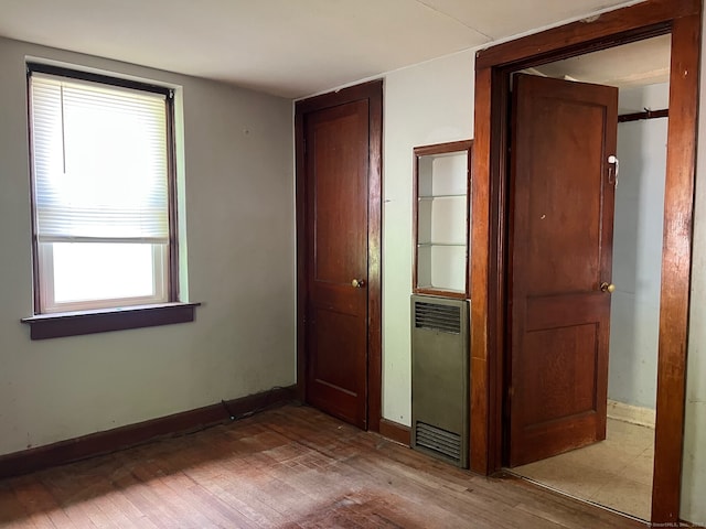 241 Harwinton Ave, Torrington, CT 06790 - unfurnished bedroom with wood finished floors, baseboards, multiple windows, and a closet