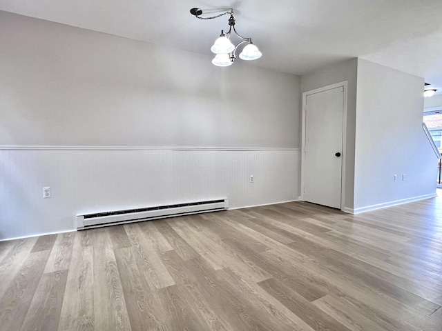 200 Yale St Unit 15B, Waterbury, CT 06704 - empty room featuring a notable chandelier, wainscoting, a baseboard heating unit, and wood finished floors