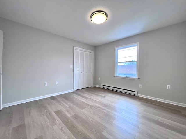 200 Yale St Unit 15B, Waterbury, CT 06704 - unfurnished bedroom featuring a closet, wood finished floors, baseboards, and a baseboard radiator
