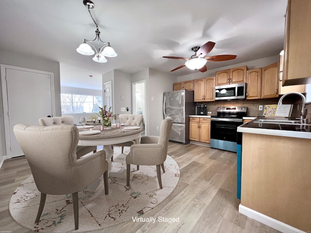 200 Yale St Unit 15B, Waterbury, CT 06704 - kitchen featuring light wood finished floors, a sink, appliances with stainless steel finishes, ceiling fan with notable chandelier, and tasteful backsplash