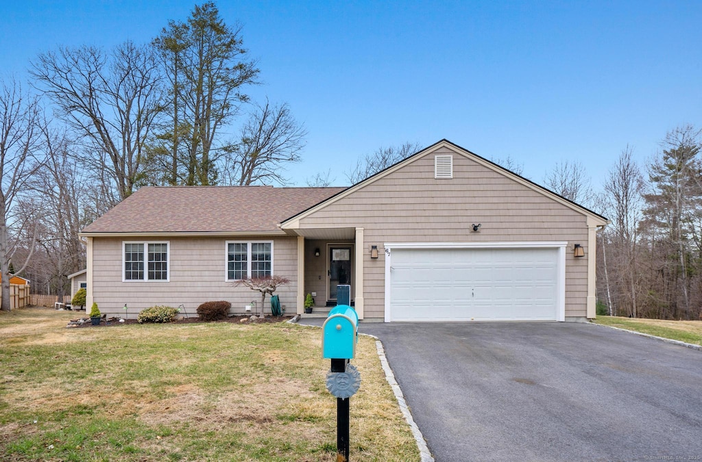 ranch-style home featuring a front lawn, a shingled roof, an attached garage, and aphalt driveway