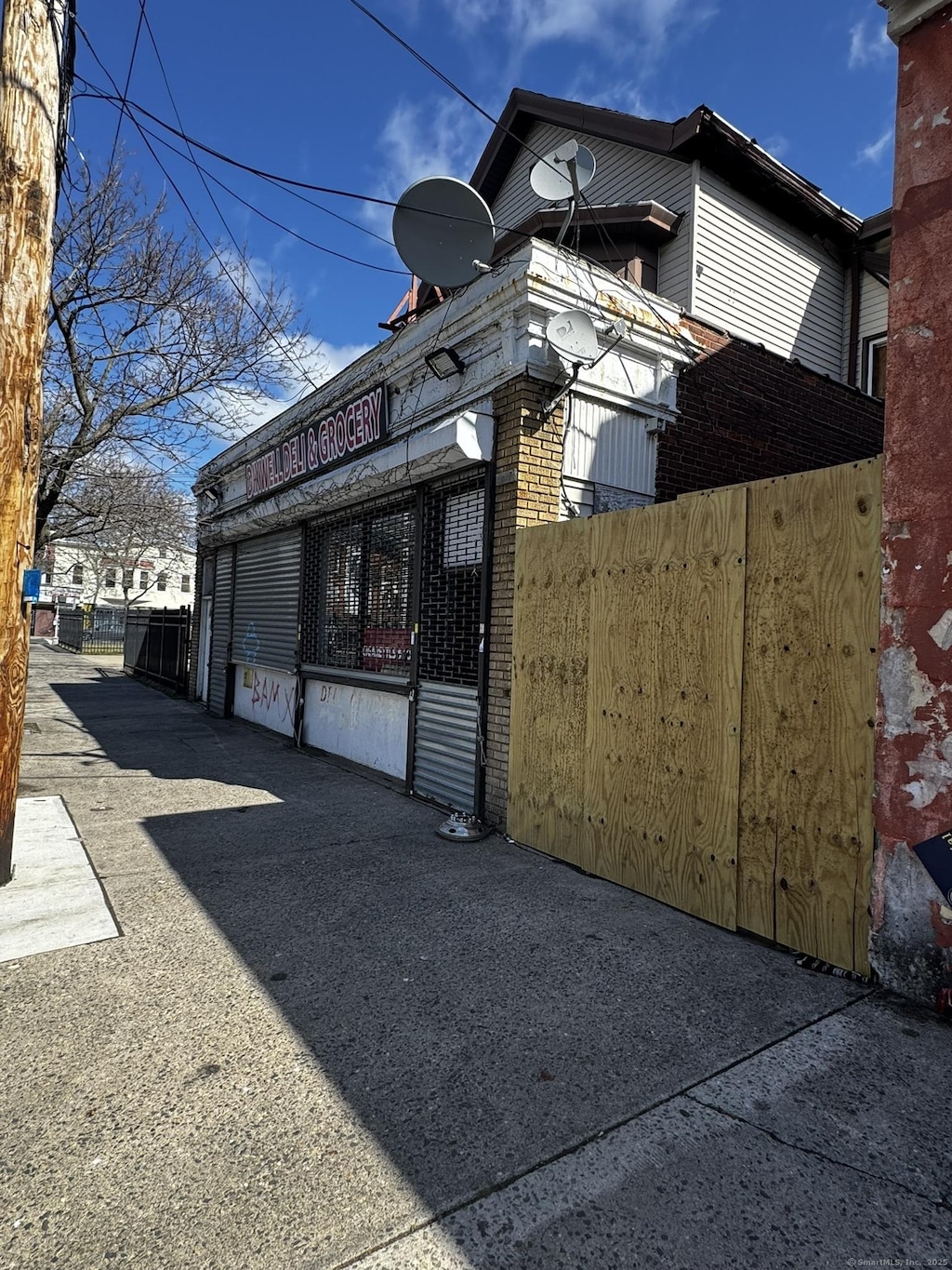 269 Dixwell Ave, New Haven, CT 06511 - view of side of property featuring a fenced front yard, a gate, and brick siding